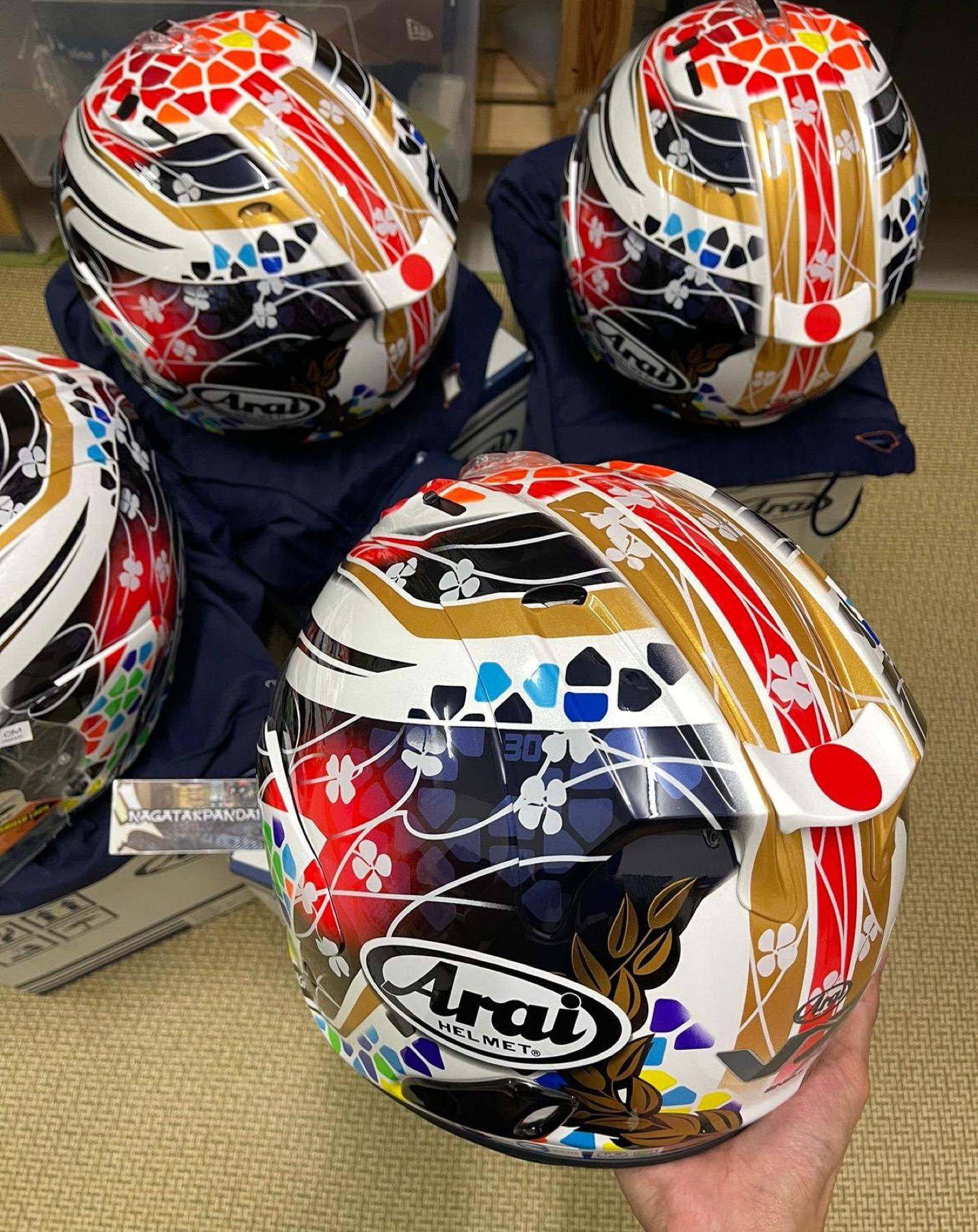 Four Arai helmets in the white, gold and red Japan flag and sakura design