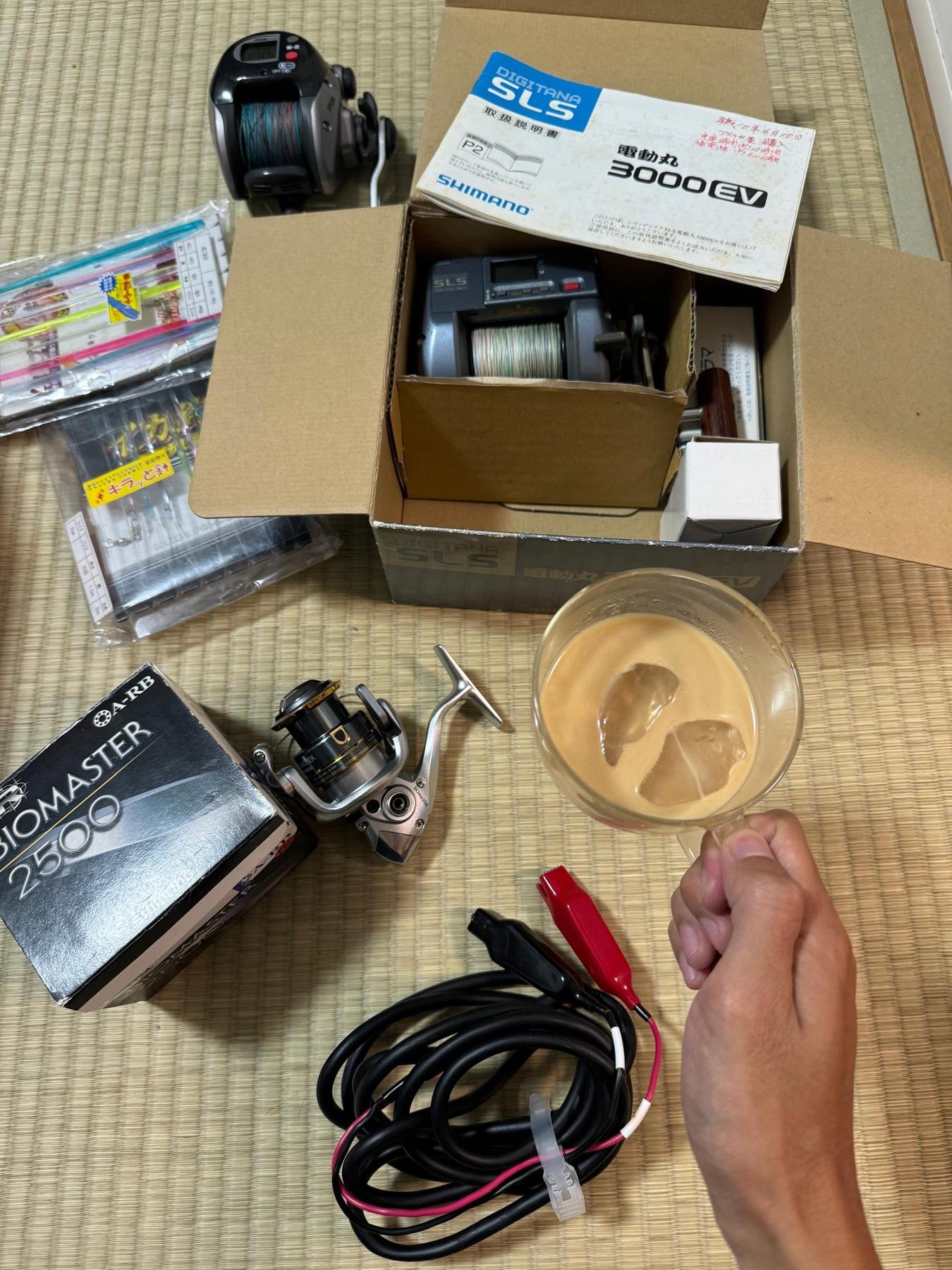 Shimano Dendou-Maru 3000EV electric reel in box with manual, Biomaster 2500 reel, power cable and iced coffee