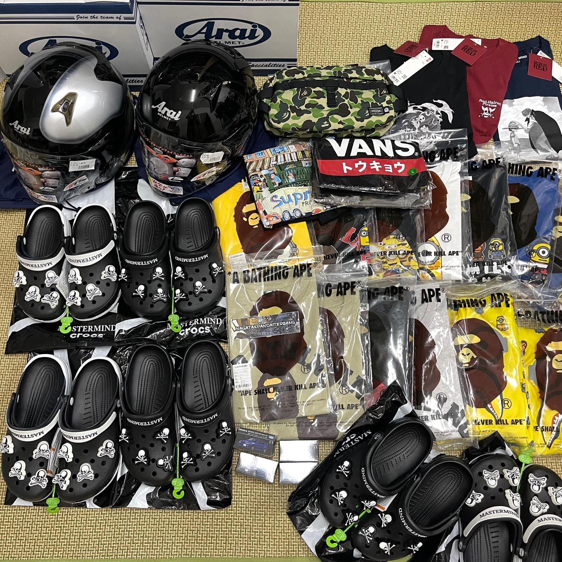 Rows of Mastermind Japan x Crocs clogs, two black Arai helmets, BAPE Minions tees and Vans Tokyo tee